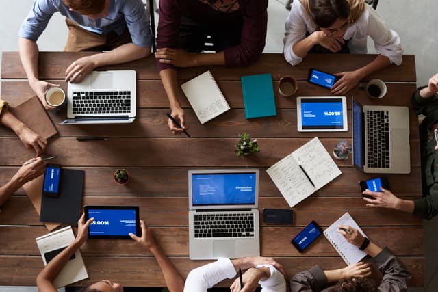 The picture every proposal sells: the team gathered and aligned. Security, though, isn't decided around the meeting table. It's decided in the code.